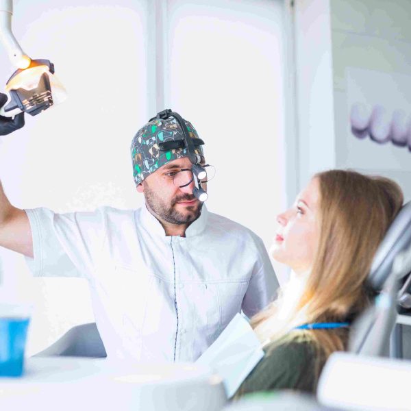 dentist-wearing-dental-loupe-binoculars-treating-female-patient_11zon